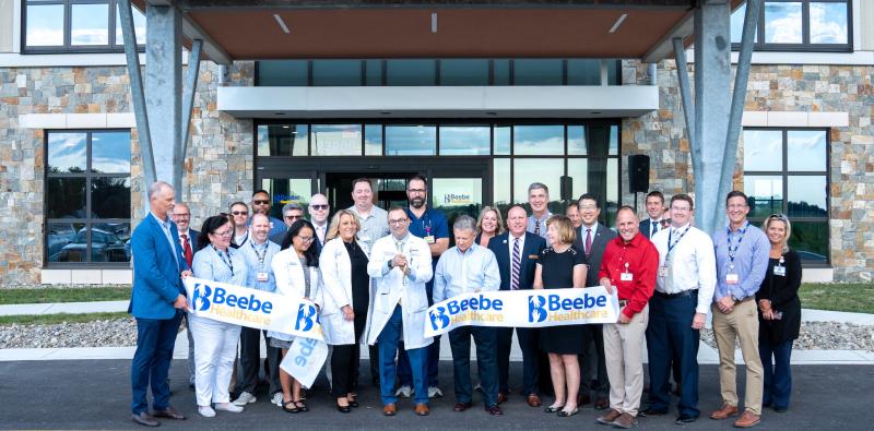 Beebe Medical Group leadership, executive leaders and clinical staff join Dr. Paul Sierzenski, chief physician executive, center, as he cuts the ribbon at the Milton Health Center. SUBMITTED PHOTO